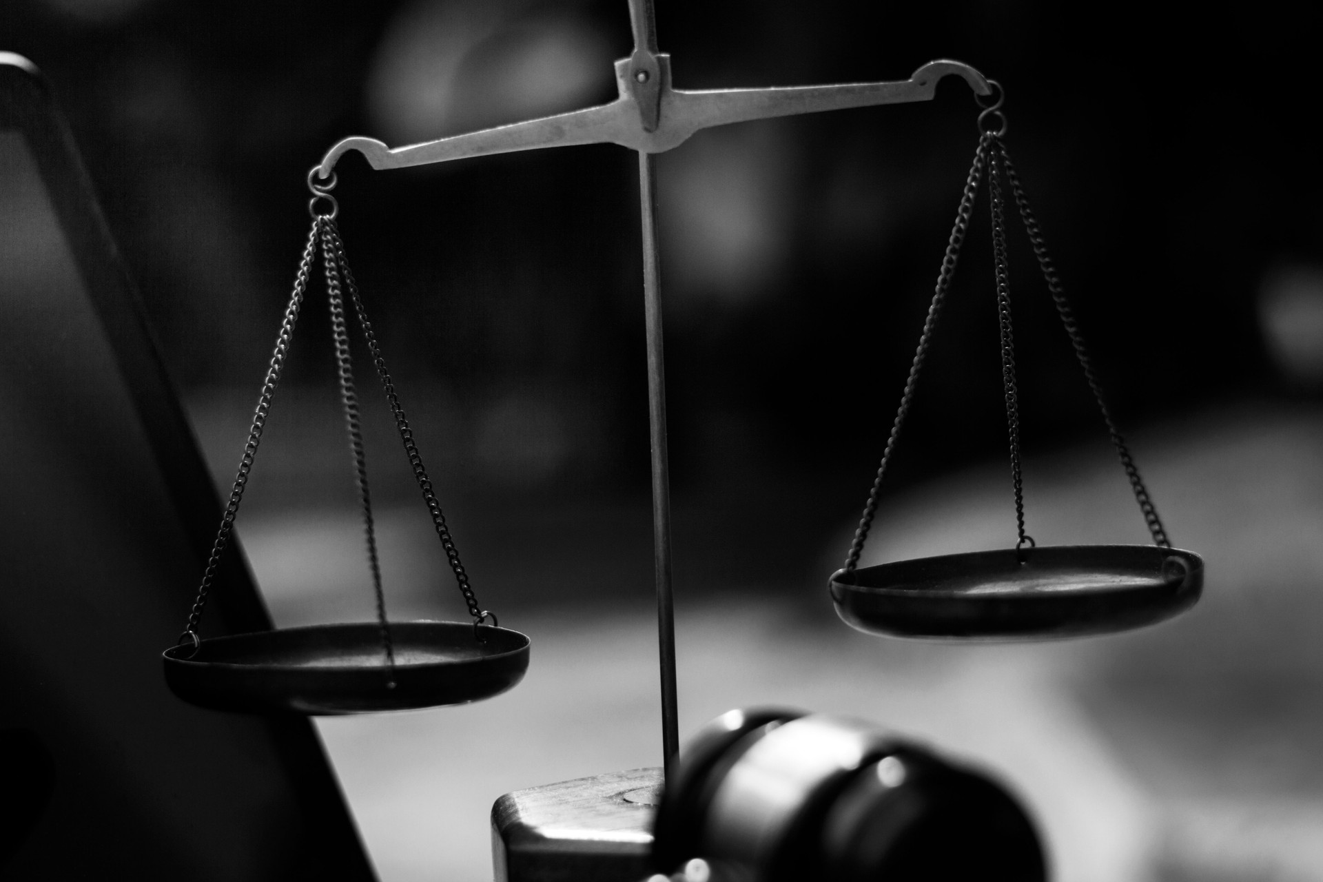 Business and lawyers discussing contract papers with brass scale on desk in office. Law, legal services, advice, justice and law concept picture with film grain effect